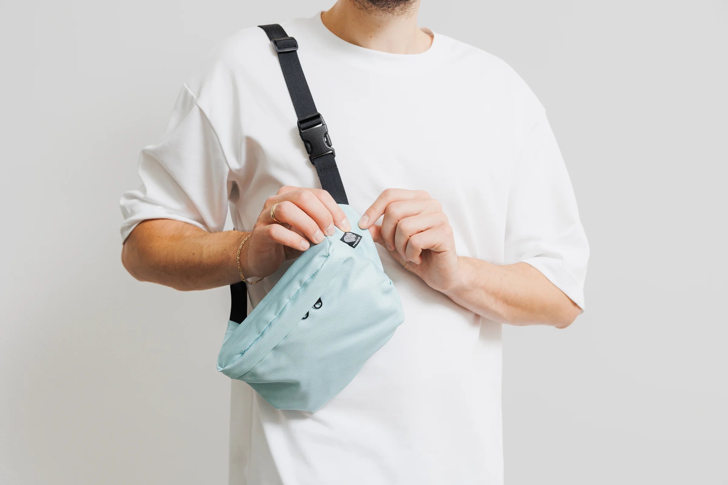 Bauchtasche aus Meeresplastik in Mint wird am Reißverschluss geöffnet